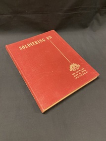 Maroon cloth bound hardcover book with title in cream print across the top, a straight line running vertical down the right side, below which is the Australian Commonwealth Military Forces emblem and the words 'the Australian Army at home and overseas'.
