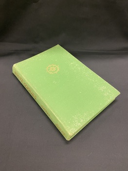 Green cloth bound book with a gold compass symbol on the front cover and gold printed heading and author on the spine.