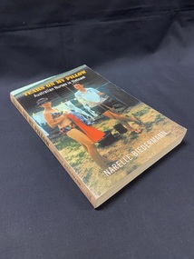 Peach coloured spine with olive printed text. Cover shows a photograph of two nurses in Vung Tau in 1968 standing by a clothes line and hanging up washing, one is wearing swimwear and the other is wearing shorts and top.
The title is printed across the top in yellow print and the sub title below that in white print.