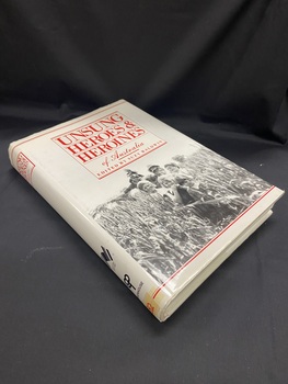 White hardcover book covered in a white dust jacket. The dust jacket has a red box, with the heading printed in red text inside, at the top half of the page. The lower half of the page shows a black and white  photo of a man and woman with six children standing in front of them and another child sitting on the man's shoulders, they are all standing in a field of tall crops. There are two horizontal red lines running along the top and bottom of the cover.