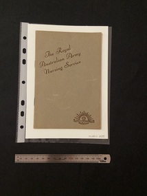 Thin, olive green booklet with two staples in the spine. The title is printed in brown ink on a slight diagonal angle towards the top of the cover. There is the Australian Commonwealth Military Forces emblem in the bottom right corner, also printed in brown ink.