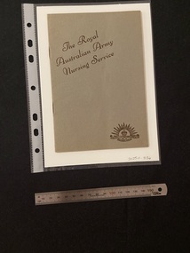 Thin, olive green booklet with two staples in the spine. The title is printed in brown ink on a slight diagonal angle towards the top of the cover. There is the Australian Commonwealth Military Forces emblem in the bottom right corner, also printed in brown ink.