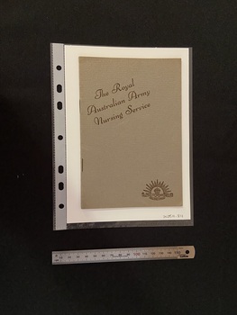 Thin, olive green booklet with two staples in the spine. The title is printed in brown ink on a slight diagonal angle towards the top of the cover. There is the Australian Commonwealth Military Forces emblem in the bottom right corner, also printed in brown ink.