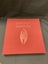 Cloth covered burgundy slipcase with the title embossed in the top centre and an image of a bat embossed in the centre.