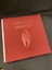 Cloth covered burgundy slipcase with the title embossed in the top centre and an image of a bat embossed in the centre.