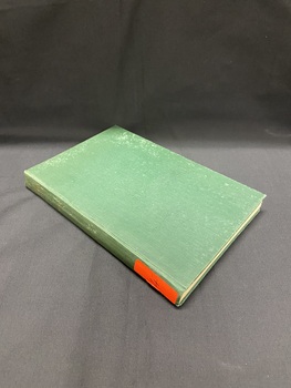 Dark green, faded cloth bound book with a bright orange sticker at the bottom of the spine.