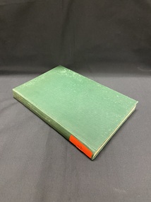Dark green, faded cloth bound book with a bright orange sticker at the bottom of the spine.