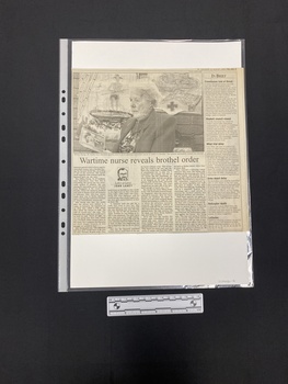 A large newspaper clipping consisting of a large black and white photo with a story of four columns of text underneath, with a column of brief stories to the right