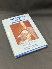 Royal blue hardcover book with a light blue dustjacket. The title and authors are printed in blue along the spine. In the middle of the spine is a white sticker with '146A 2nd copy' handwritten on it. The front shows a large portrait of Jane Bell, The title is printed in dark blue above the image, below the image (in smaller text) is the sub-heading and author's names.