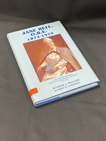Royal blue hardcover book with a light blue dustjacket. The title and authors are printed in blue along the spine. At the base of the spine is an orange sticker with 'B 146' handwritten on it. The front shows a large portrait of Jane Bell, The title is printed in dark blue above the image, below the image (in smaller text) is the sub-heading and author's names.