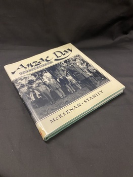Green hardcover book with cream coloured dustjacket. There is a black and white photo that wraps around the whole dustjacket depicting a crowd at a Memorial Service in Toronto, New South Wales. On the front section of the dustjacket the title is printed above the photo and the author is printed below, both in black print.