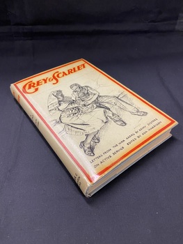 Grey dust jacket covered hardback book. There is a red border around the front and the title printed in red across the top. The centre of the cover shows a hand-drawn image of a nurse tending a wounded patient at his bedside. The subtitle is printed across the bottom in black. 
The title is printed in red at the top of the spine and below that, in black print, it reads : 'with a forward by Her Majesty Queen Mary'.