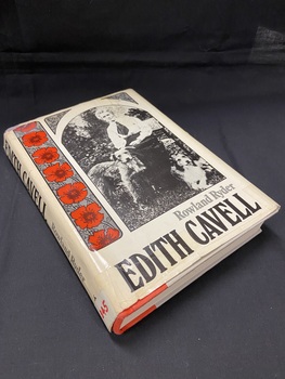 Hardback book with dustjacket. The dustjacket is cream in colour. Along the spine the title is printed in large black letters, followed by the author's name, and at the bottom is a white sticker with 'B45' handwritten in red texta.
The front of the dustjacket shows a black and white photograph of a well-dressed lady sitting on a bench with a dog either side of her. Down the left side of the image is a vertical panel with seven red poppies. The title and author are printed across the bottom of the cover.