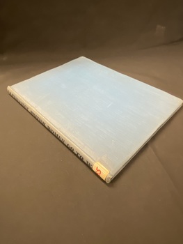 Faded blue clothbound hardcover book. The title is printed in black along the spine and there is a white sticker with B55 written in red ink taped to the bottom of the spine.