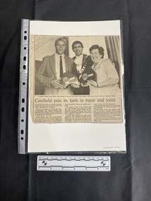 A newspaper clipping featuring a large black and white photo above a title and three small columns of text