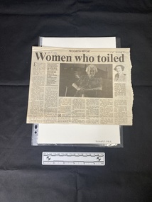 A newspaper clipping including seven columns of text and two black and white photos