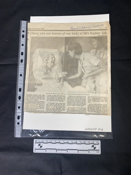 A [newspaper] clipping featuring a large black and white photo and four columns of text