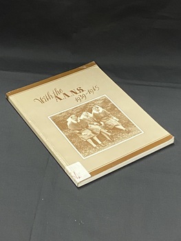 Light brown book with dark brown line across the top and bottom and the title printed in dark brown across the top. There is a sepia toned photo of three nurses sitting by some ferns below the title. There is a white sticker wrapped around the bottom of the spine with B134 handwritten in red ink.