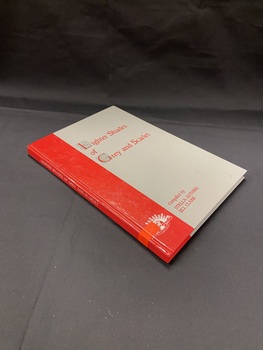 Grey book with a red vertical block down the left side that continues around the spine. The title is printed in red text on the front. There is a bright orange sticker near the lower part of the spine.