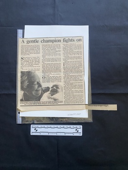 A newspaper clipping of a story consisting of three large columns of text and a large black and white photo