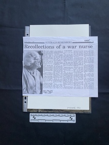 A photocopy of a newspaper clipping featuring a large black and white photo and five columns of text