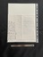 The back of the page has nine lines of handwritten text in black ink running vertically along the left side of the page. The right side shows an inscription handwritten in pencil.