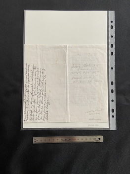 The back of the page has nine lines of handwritten text in black ink running vertically along the left side of the page. The right side shows an inscription handwritten in pencil.