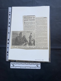 A newspaper clipping consisting of two columns of text and a black and white photo