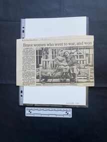 A newspaper clipping consisting of a column of text and a large black and white photo