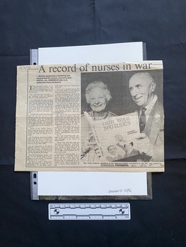 A large newspaper clipping consisting of two columns of text and a large black and white photo