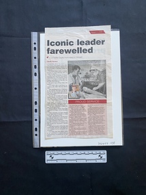 A newspaper clipping of a story consisting of three columns of text, a black and white photo and a small colour photo