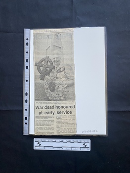 A newspaper clipping of a large black and white photo above two small columns of text