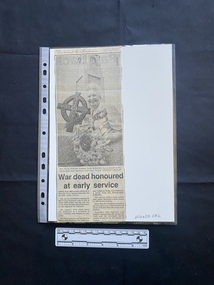 A newspaper clipping of a large black and white photo above two small columns of text