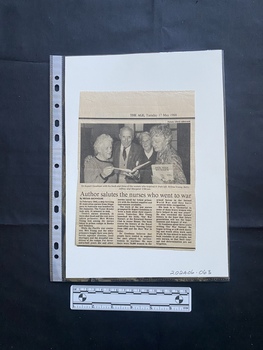 A newspaper clipping of three columns of text beneath a large black and white photo