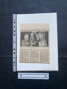 A newspaper clipping of three columns of text beneath a large black and white photo
