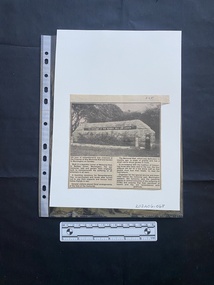 A newspaper clipping consisting of four columns of text and a title under a large black and white photo