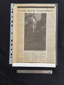Large article cut from a newspaper page. Title across the top with five columns of text below. The left and right columns run the full length of the page. The middle columns are quite small and above them is a large photo image of a nurse in uniform.