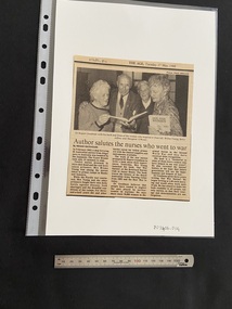 Newspaper clipping with publication title and date at the top and a photograph above three columns of text. Black and white photograph is of three older women and one older man holding copies of a book in their hands.