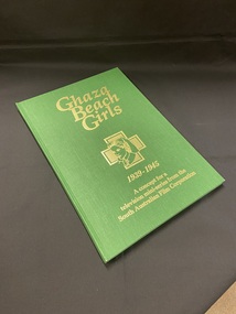 Green cloth bound cover with title details printed in gold. In the middle of the cover is a gold outline of an army nurse with a gold cross behind the portrait.