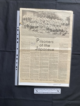 Large newspaper page with a story consisting of five columns of text and a large, bold title beneath a large black and white group photo