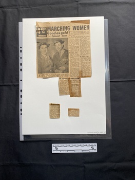 Newspaper clipping of articles on both sides, with some parts becoming seperated. One side has a black and white photograph of three woman wearing medals and holding a floral tribute.  The other side has a black and white photograph of two women in Army nursing uniforms looking at the camera.  There are a range of articles on both sides.