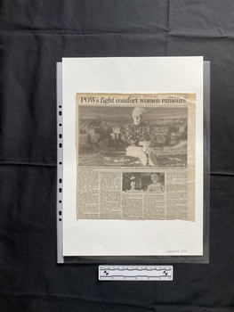 A large newspaper clipping featuring a large black and white photo with a smaller photo beneath and five columns of text