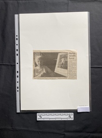 A small newspaper clipping with one column of text and a large black and white photo