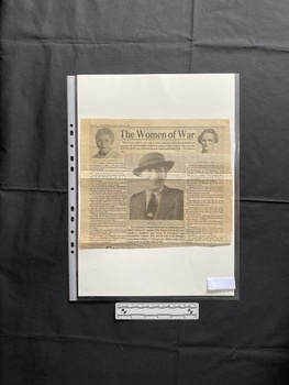 A large newspaper clipping with two large columns of text and three black and white photos