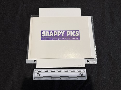 A white card folder approximately A5 landscape in size, closed with white writing surrounded in purple on front cover