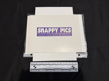 A white card folder approximately A5 landscape in size, closed with white writing surrounded in purple on front cover