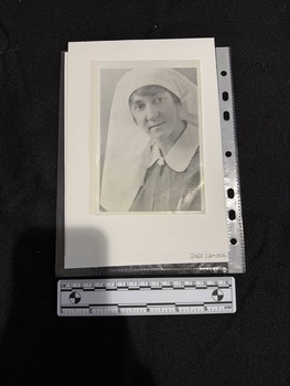 Black and white portrait photograph of a younger woman in a nurses uniform with a white collar and headdress.  Photo is a little blurry.