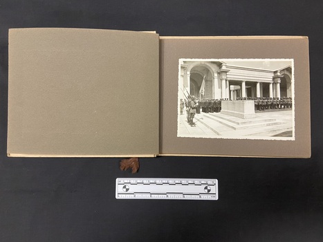An example of the inside pages of the album showing a blank page to the left and a single black and white photograph attached to the page on the right.