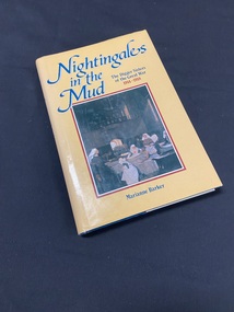 Blue hardcover book with a yellow dustjacket. The title is printed down the spine in blue text. The front cover shows an image of an oil painting of nurses tending the beds of the wounded, it is surrounded by a dark red border. Above the image the title is printed in blue, with 1914-1918 printed in smaller red print.