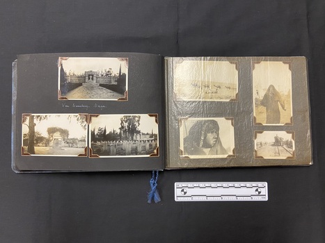 An example of the inside album layout. This image shows the left side with three photographs. The right side is covered with a translucent protective sheet, beneath which is a layout of five photographs and two annotations in white ink.